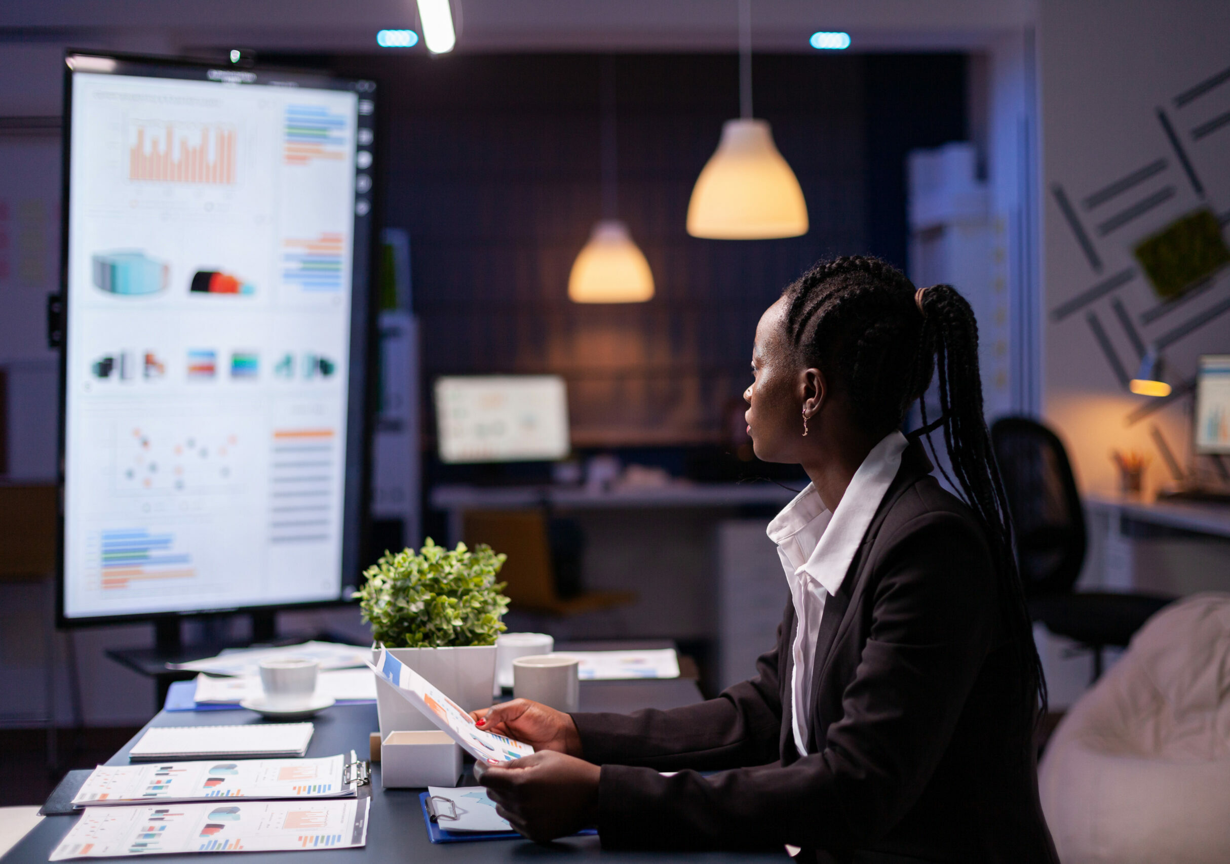 Focused workaholic african american businesswoman working at company financial charts presentation